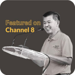 Client speaking at a podium, featured on Channel 8