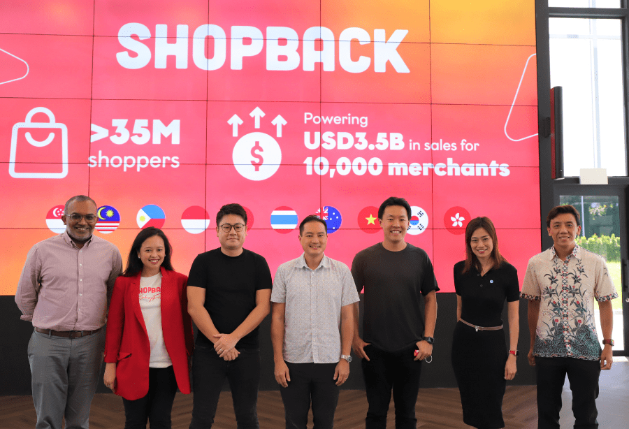 ShopBack team posing in front of a pink wall displaying 35M shoppers and USD3.5B sales stats