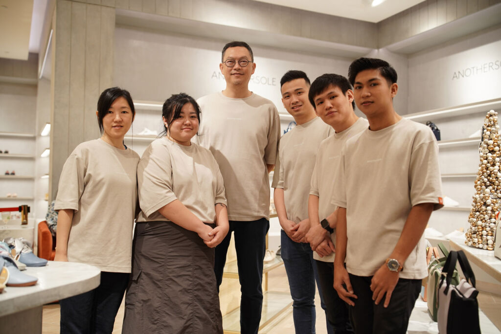Anothersole team posing together inside the brand's retail store