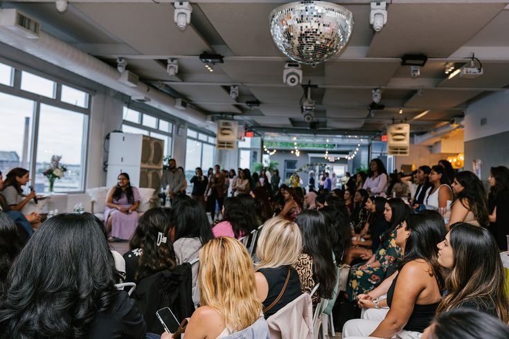 Audience seated under a disco ball at a Mai Soli Foundation women's empowerment event in NYC